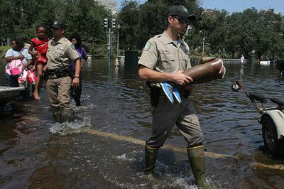A Texas game warden carries the prosthetic legs of a patient as other officers assist in the evacuation of people from Tulane University Hospital, Wed., Aug. 31, 2005, in New Orleans.