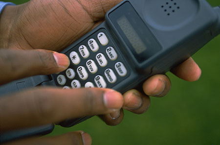 Photo of a hand punching a button on a telephone.