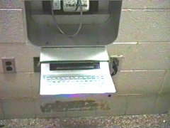 Photo of a TTY pay phone.  The TTY is in a metal box under the pay phone.