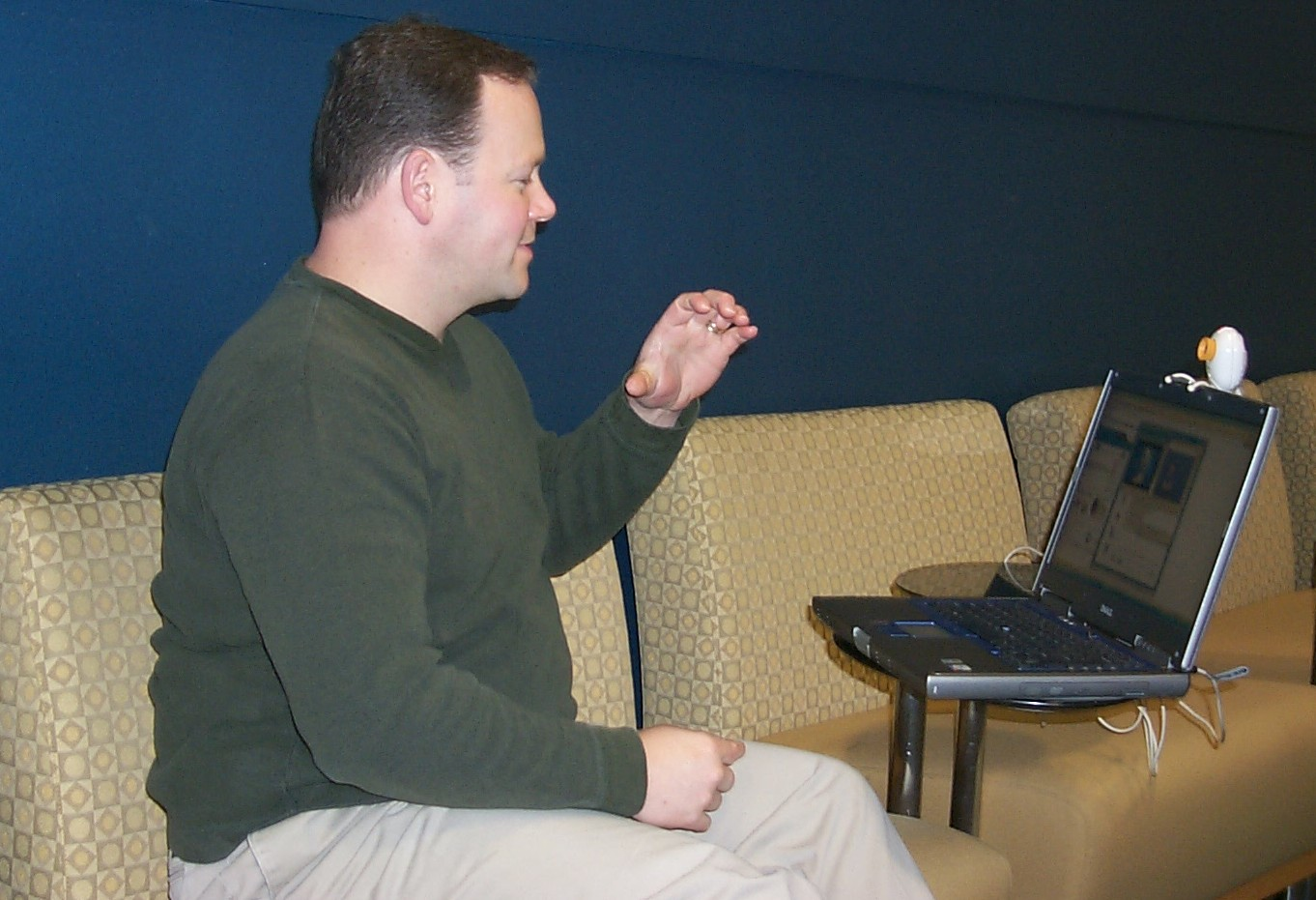 Photo of a man involved in a video call on a laptop computer.