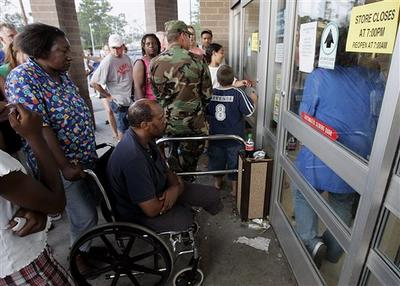 A photo of Gwendolyn Swor, a middle aged African American woman, pushes her frined Walter Griffins, in his wheelchair as they wait for their turn to be let in to a drug store to shop in Hattiesburg, Miss.